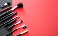 Make-up brushes set against red and black background, copy space Royalty Free Stock Photo