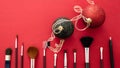 Make-up brushes and xmas decoration against red background, copy space Royalty Free Stock Photo