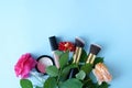 Make-up cosmetics with flowers on blue background, copy space. beauty , blogging