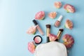 Make up cosmetics with pink flowers on blue background with copy space Royalty Free Stock Photo