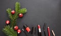 Make-up products and xmas decoration against black background, copy space Royalty Free Stock Photo