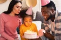 Family blowing out candles on a cake Royalty Free Stock Photo