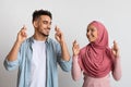 Make A Wish. Portrait Of Young Muslim Couple Crossing Fingers For Luck Royalty Free Stock Photo