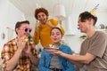 Make a wish. Woman wearing party cap blowing out burning candles on birthday cake. Happy Birthday party. Group of Royalty Free Stock Photo