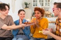 Make a wish. Woman wearing party cap blowing out burning candles on birthday cake. Happy Birthday party. Group of Royalty Free Stock Photo