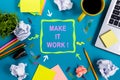 Make it work. Office table desk with supplies, white blank note pad, cup, pen, pc, crumpled paper, flower on wooden