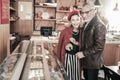 Positive delighted mature people choosing sweets for coffee Royalty Free Stock Photo