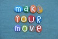 Make your move, motivational message composed with multi colored stone letters over green sand Royalty Free Stock Photo