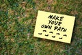 Make your own path message written on paper on green grass background. Motivational quote to create future in business or life Royalty Free Stock Photo