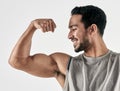 Make yourself proud over and over again. Studio shot of a muscular young man flexing his biceps against a white Royalty Free Stock Photo