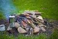 The maker stands near a fire outdoors. Royalty Free Stock Photo