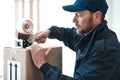 He always makes sure every package is sealed properly. a handsome delivery man sealing a package while out making