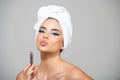 Makeup, applies cosmetics. Woman with towel on head applies red lipstick, painting lips of young beauty model girl Royalty Free Stock Photo