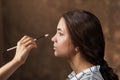 Makeup artist applies nude makeup to emphasize the natural beauty of the girls face