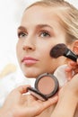 Makeup artist apply blush on cheeks