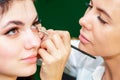 Makeup artist is applying eyeliner on eyes Royalty Free Stock Photo