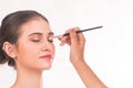 Makeup artist applying eyeshadow for beautiful woman on white background Royalty Free Stock Photo