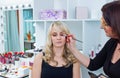 Makeup artist applying eyeshadow on womans eyes Royalty Free Stock Photo