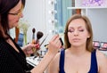 Makeup artist applying eyeshadow on womans eyes Royalty Free Stock Photo