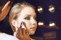 Makeup artist applying liquid tonal foundation on the face of the woman Royalty Free Stock Photo