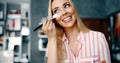 Makeup artist applying liquid tonal foundation on the face of the woman in make up room Royalty Free Stock Photo