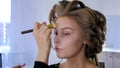 Makeup artist applying liquid tonal foundation on woman`s face Royalty Free Stock Photo