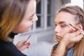 Makeup artist applying make up on alluring model