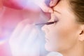 Makeup artist applying mascara on bride eyelashes.