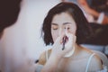 Makeup artist applying pink eyeshadow to beautiful Asian model Royalty Free Stock Photo