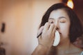 Makeup artist applying pink eyeshadow to beautiful Asian model Royalty Free Stock Photo