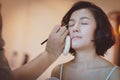 Makeup artist applying pink eyeshadow to beautiful Asian model Royalty Free Stock Photo