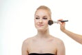 Makeup artist applying powder for beautiful young woman on white background Royalty Free Stock Photo
