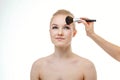 Makeup artist applying powder for beautiful young woman on white background Royalty Free Stock Photo