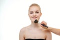 Makeup artist applying powder for beautiful young woman on white background Royalty Free Stock Photo