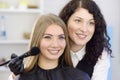 Makeup artist applying the tone of the foundation using special brush on face young beautiful model. Facial care and make up Royalty Free Stock Photo