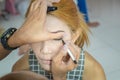 Makeup artist asian woman applying cosmetic mascara on eyelashes using curling brush Royalty Free Stock Photo