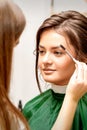 Makeup artist combing eyebrows for bride