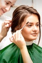 Makeup artist combing eyebrows and hairstylist preparing hairstyle