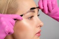 Makeup artist combs and plucks eyebrows after dyeing in a beauty salon.Professional makeup and cosmetology skin care