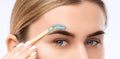 Makeup artist does facial hair removal procedure. Beautiful girl with blue eyes having Permanent Make-up on her Eyebrows. Royalty Free Stock Photo