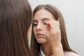 Makeup artist glues bunches on the eyelashes model