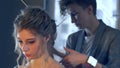 Makeup artist and hairdresser are preparing bride before wedding. Hairdresser-stylist with short stylish hairstyle applies makeup