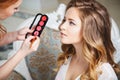 Makeup artist preparing bride before the wedding in a morning Royalty Free Stock Photo