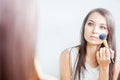 Makeup artist woman doing make-up using cosmetic brush for yourself Royalty Free Stock Photo