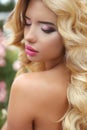 Makeup. Beautiful girl with blond long wavy hair. Fashion model