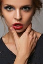 Makeup and beauty theme: beautiful girl with red lips and blue eyes in studio