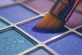 Makeup brush on blue shadows. Bright shadows for the summer. Macro frame of shadows. Bright cosmetics, fashionable colors. Royalty Free Stock Photo