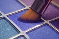 Makeup brush on blue shadows. Bright shadows for the summer. Macro frame of shadows. Bright cosmetics, fashionable colors. Royalty Free Stock Photo