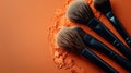 Makeup brush collection splayed on an orange field.