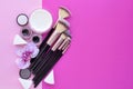 Makeup brush and decorative cosmetics and a orchid flower on pink background. Royalty Free Stock Photo